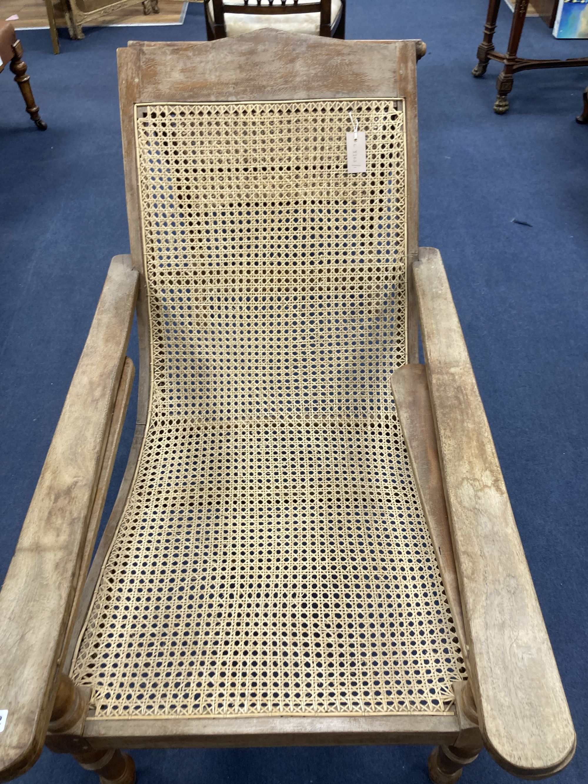 An early 20th century Anglo-Indian caned weathered plantation chair, width 66cm, depth 104cm, height 91cm